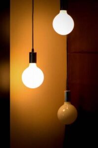 Home Service Blogs | Grand Bay Electrical Three Hanging Light Bulbs, Two Lit And One Unlit, Against A Warm Brown Background.