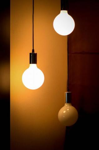 Three Hanging Light Bulbs, Two Lit And One Unlit, Against A Warm Brown Background.